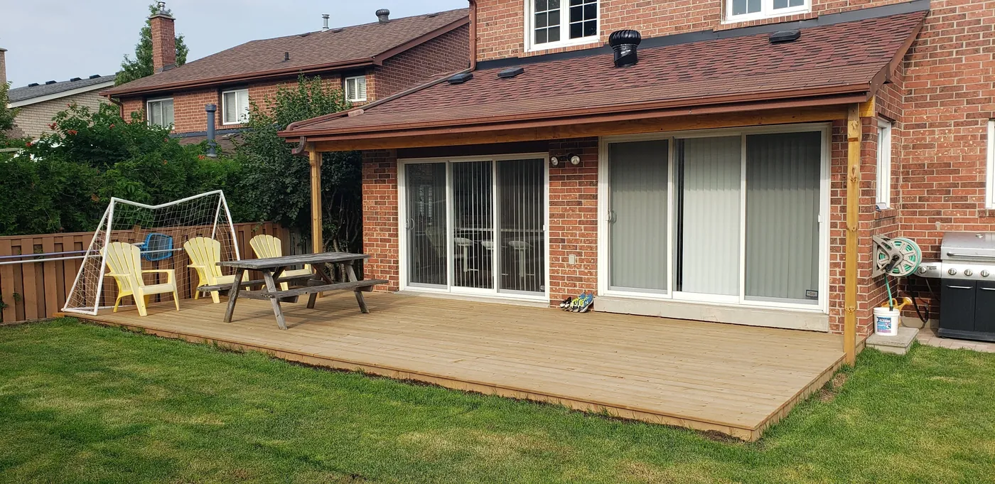 Covered pressure-treated deck seen from across the back lawn, Aurora