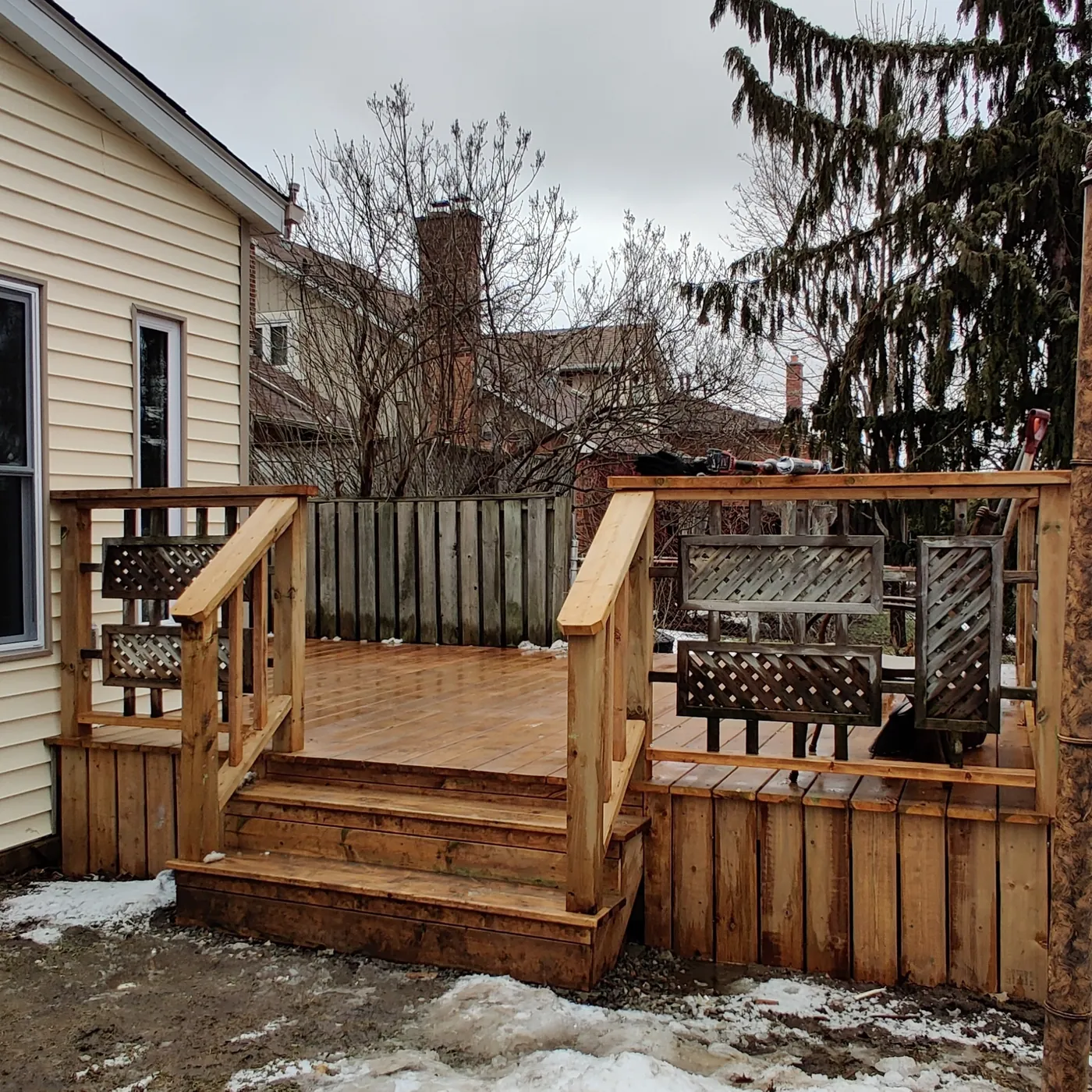 Deck steps and lattice-panel railing down to the yard, Brampton