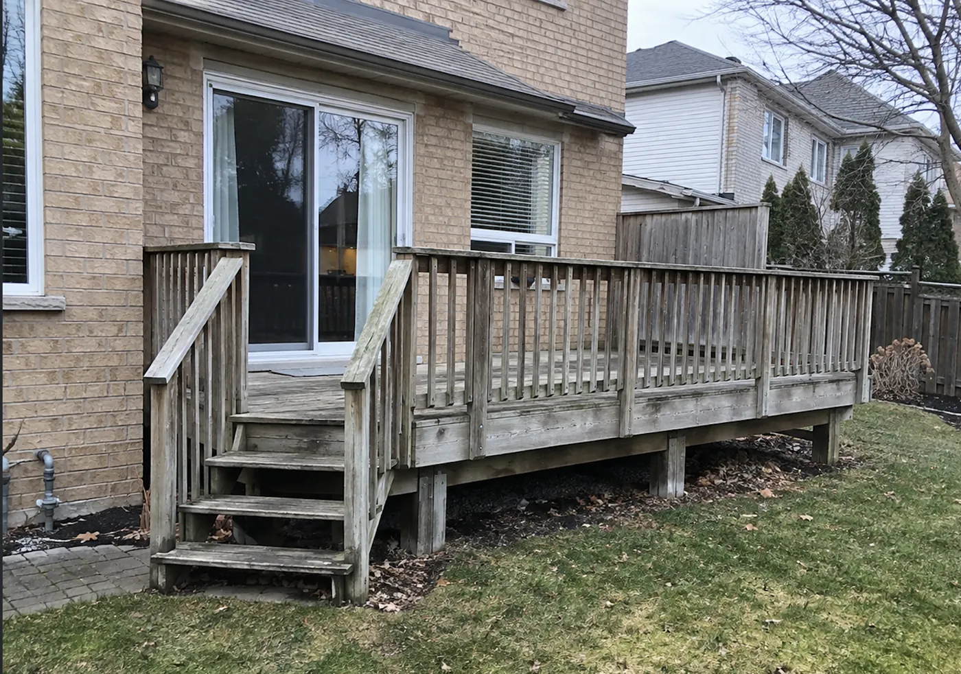 The original weathered deck and wood picket railing in Burlington before the rebuild