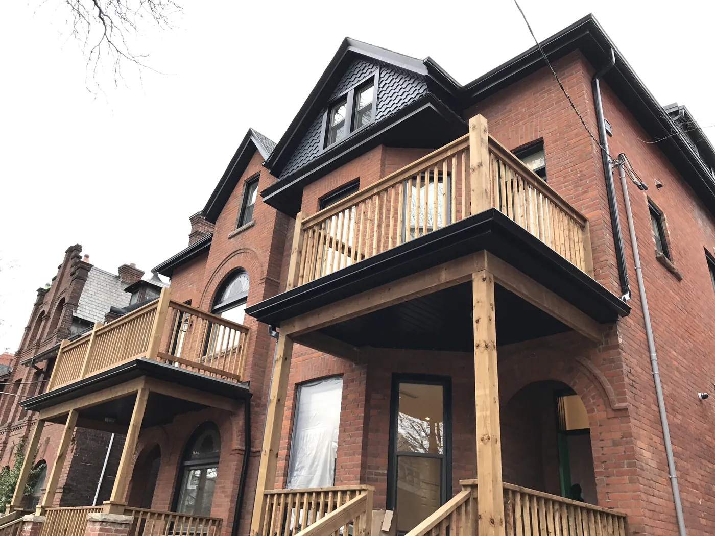 New upper and lower porch decks on a pair of heritage brick units, Etobicoke