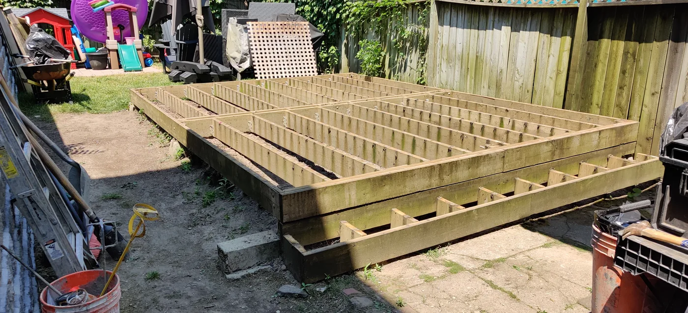 New pressure-treated deck frame and joists set out in the King City backyard