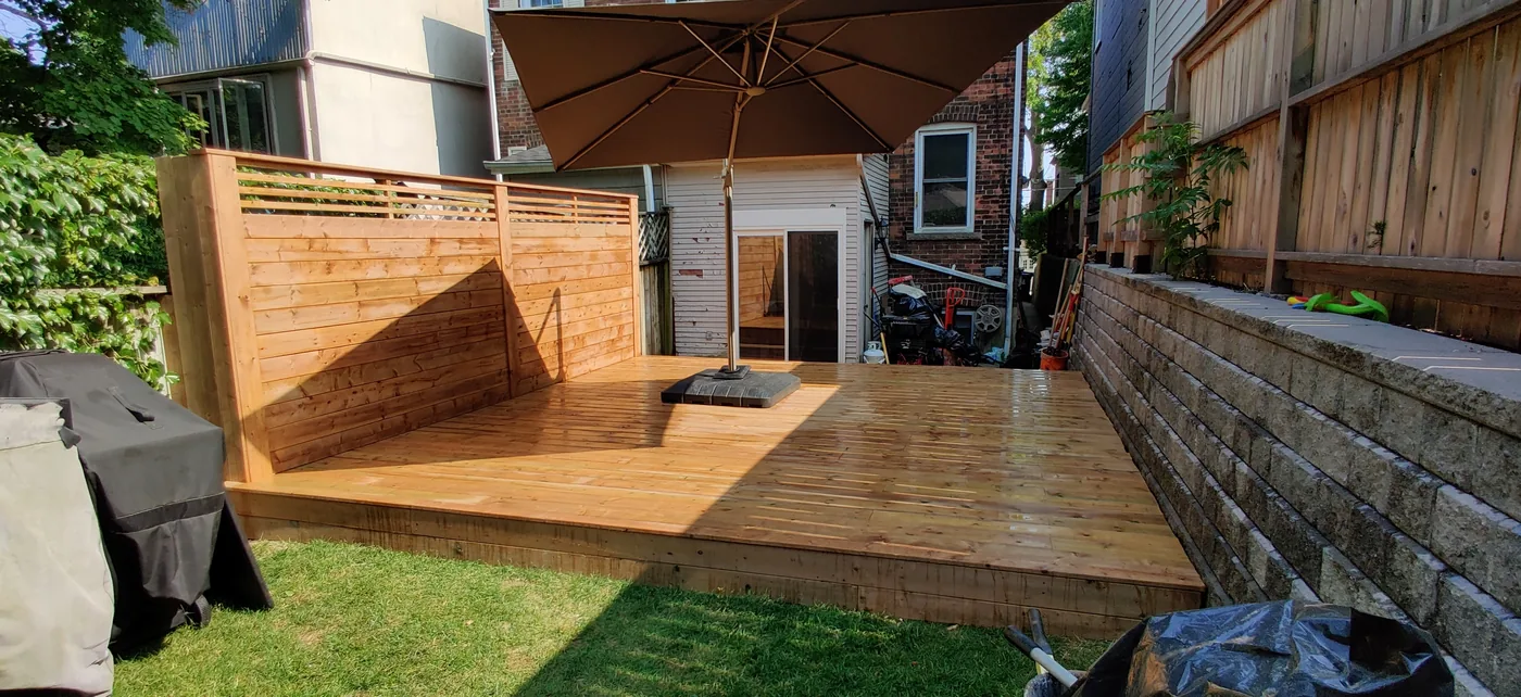 Pressure-treated deck and horizontal privacy wall seen from the lawn in King City