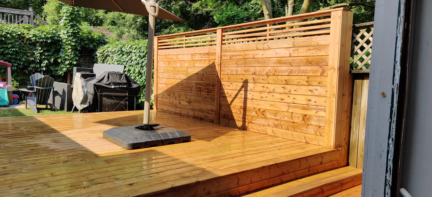 Horizontal privacy wall with an open slat top along the edge of a King City deck