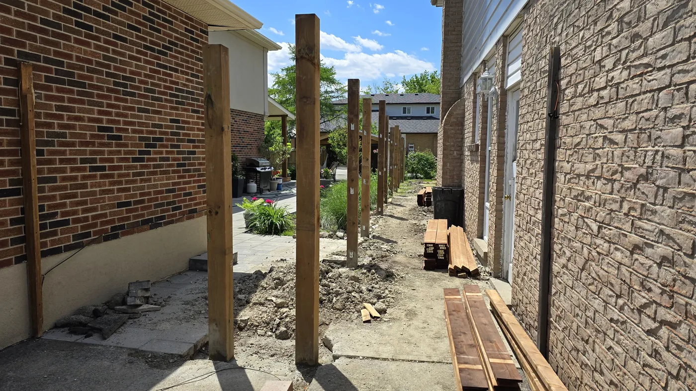 New fence posts on steel bases anchored to the existing concrete path, Markham