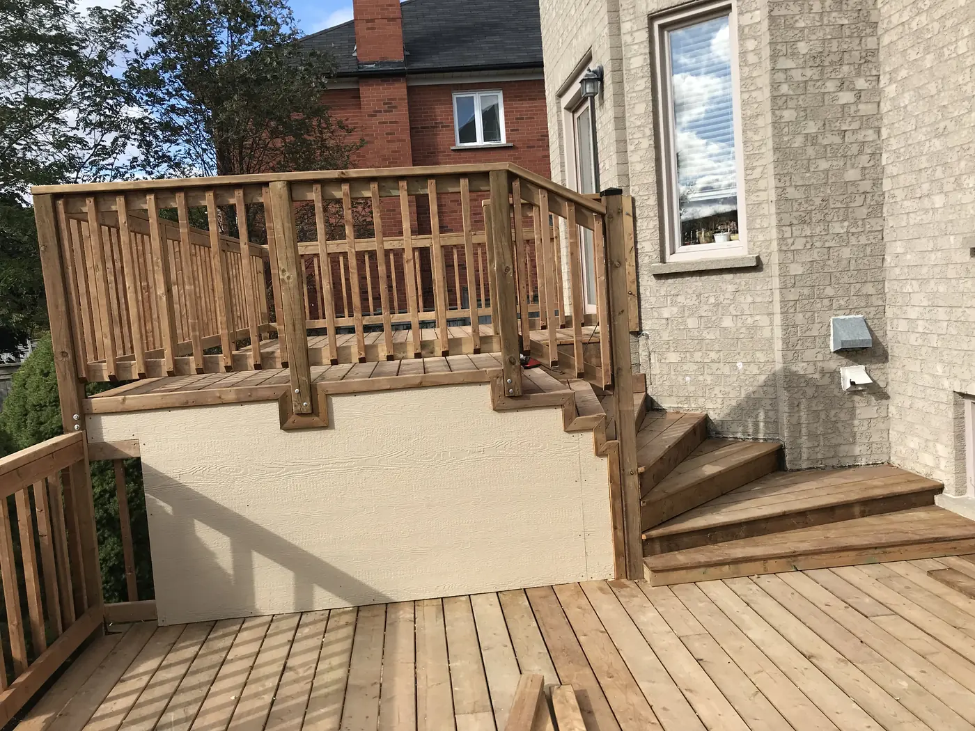Upper deck with wood railings and finished skirting above the lower deck in Markham