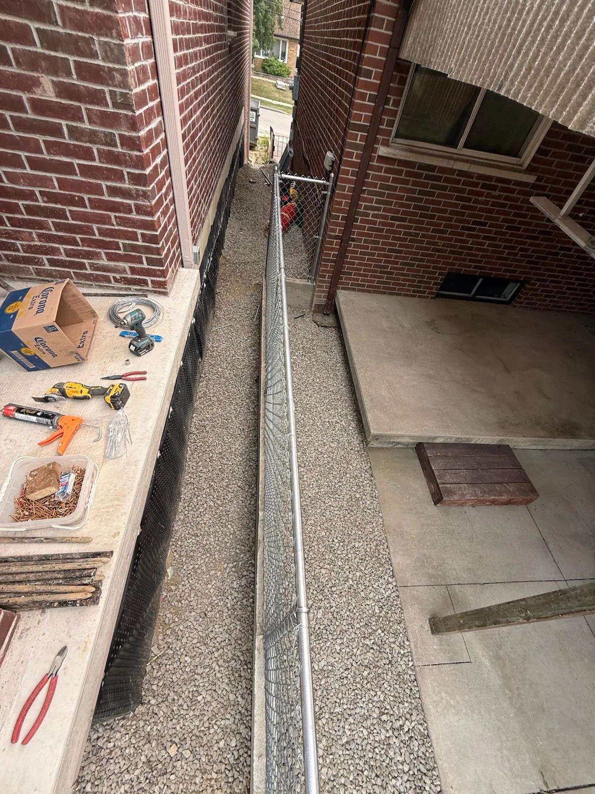 Chain link posts and mesh going up along the new concrete base in Mississauga