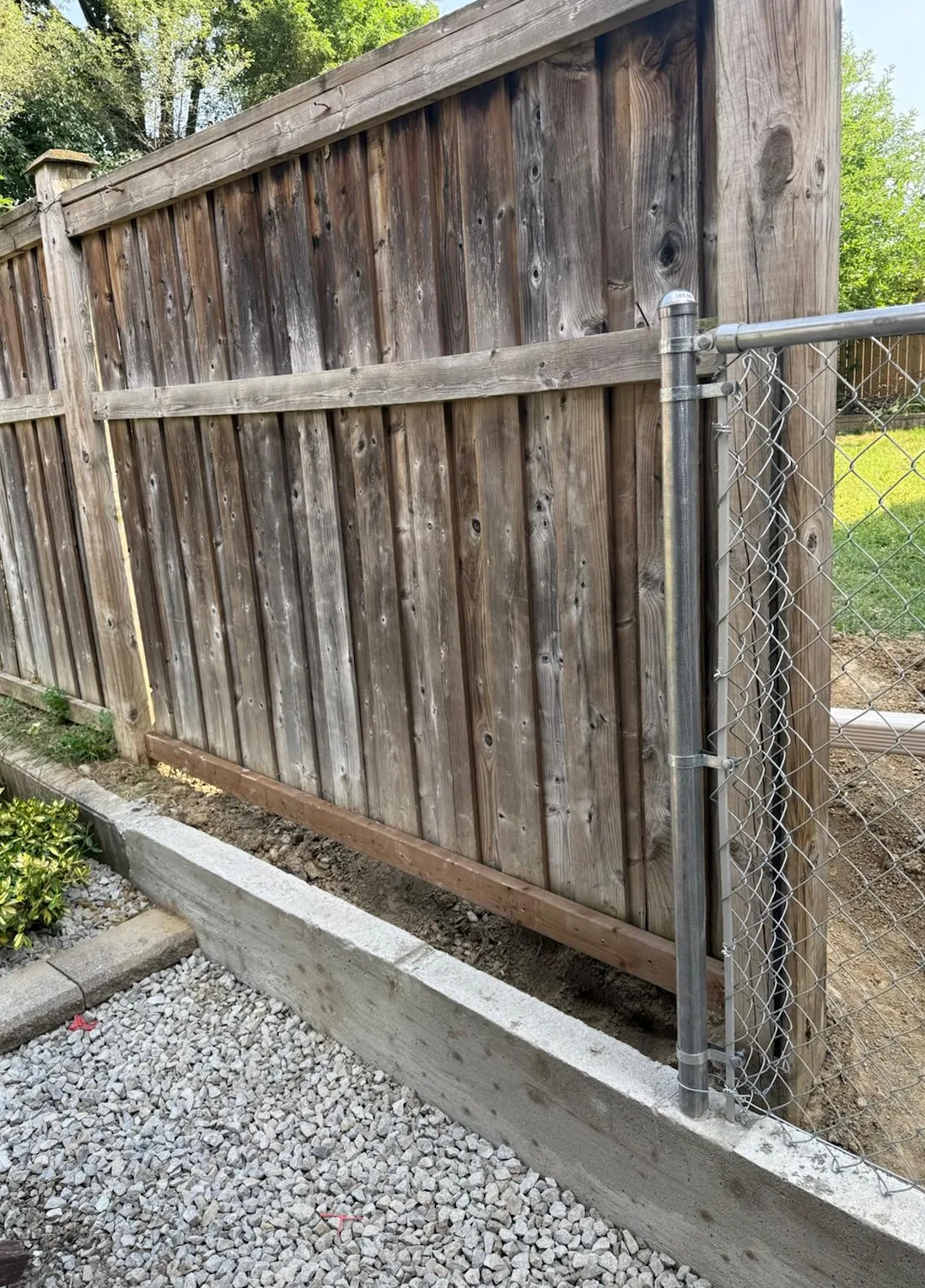 New chain link and concrete base meeting the existing wood fence at the rear, Mississauga