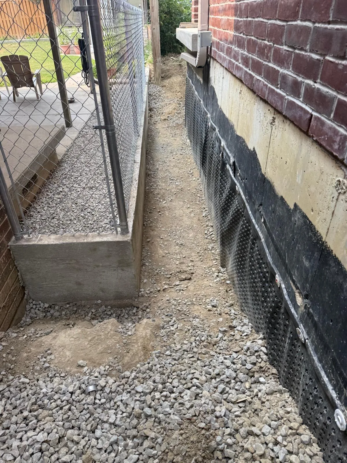 The poured concrete base holding back the gravel and grade beside the foundation, Mississauga