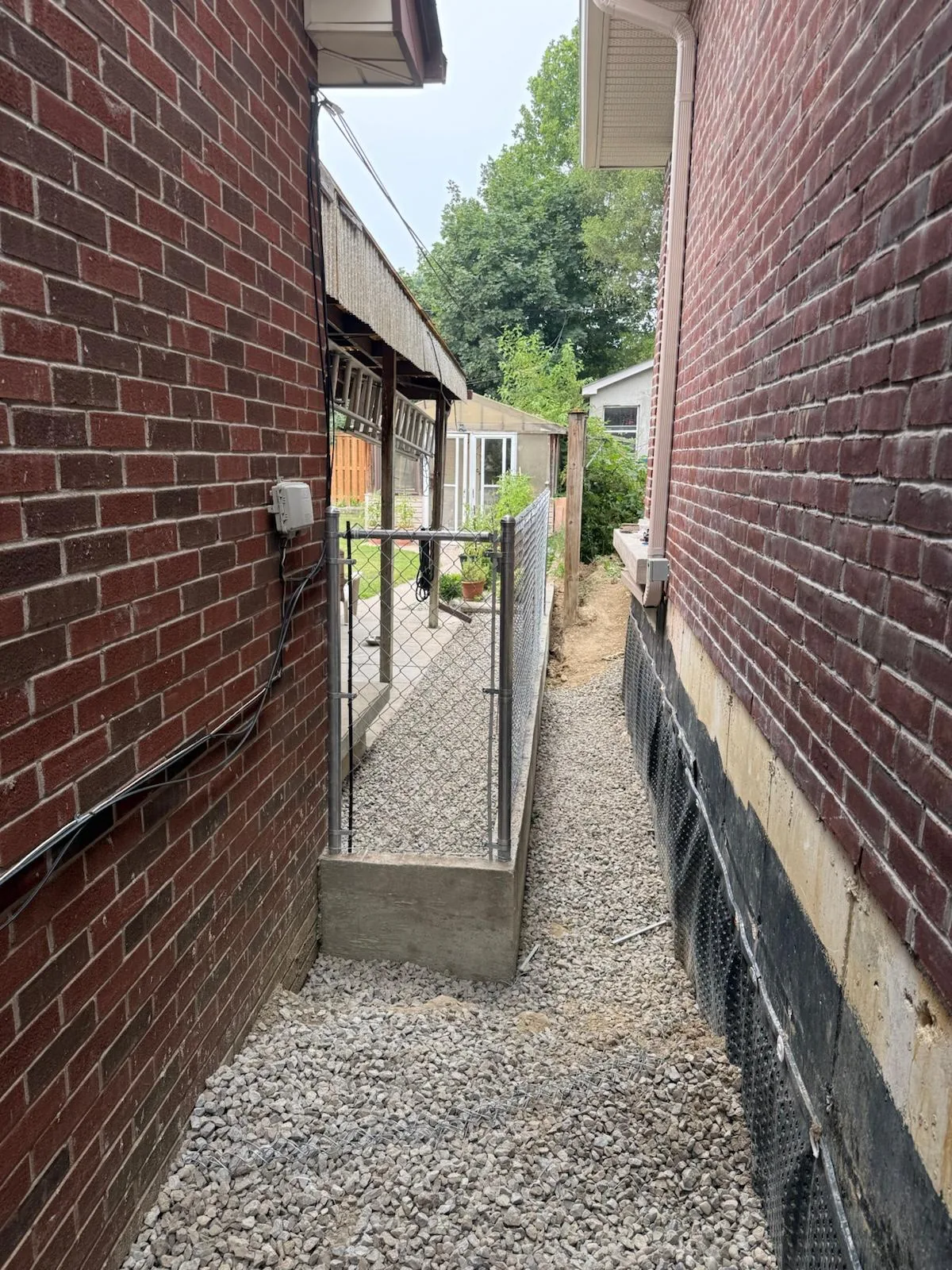 The finished chain link run down the narrow side yard between two houses in Mississauga