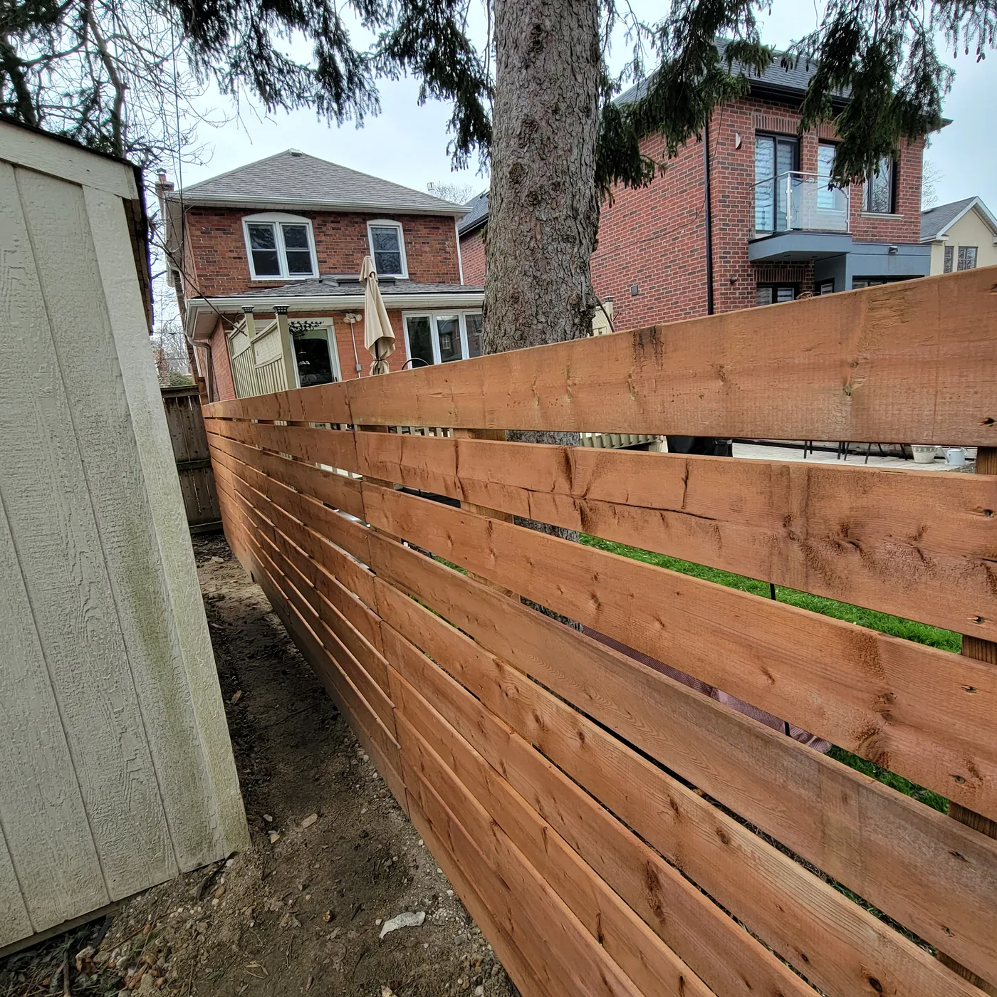 Pressure-treated horizontal board fence running along a North York side yard