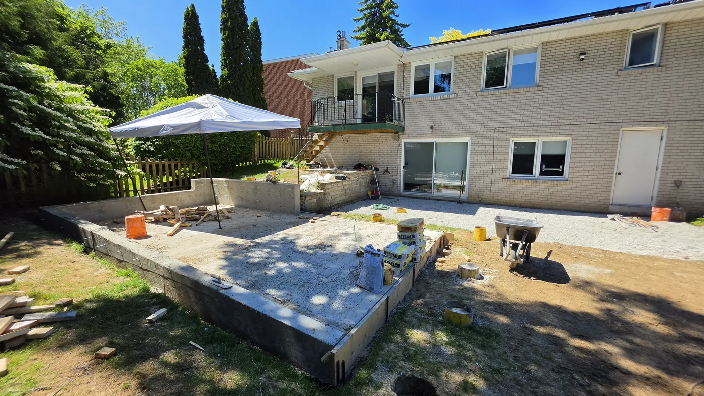 The old concrete patio and bare yard behind the North York house before the rebuild