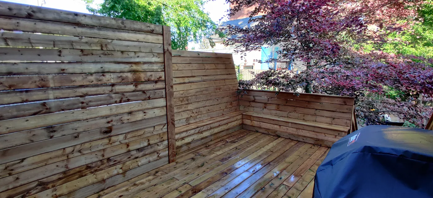Pressure-treated deck in North York enclosed by full height horizontal privacy walls with a built-in bench