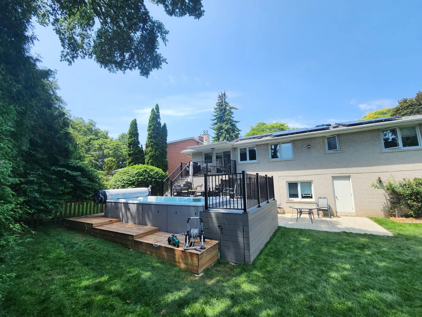 The composite deck, swim spa and wide stairs seen from the lawn in North York
