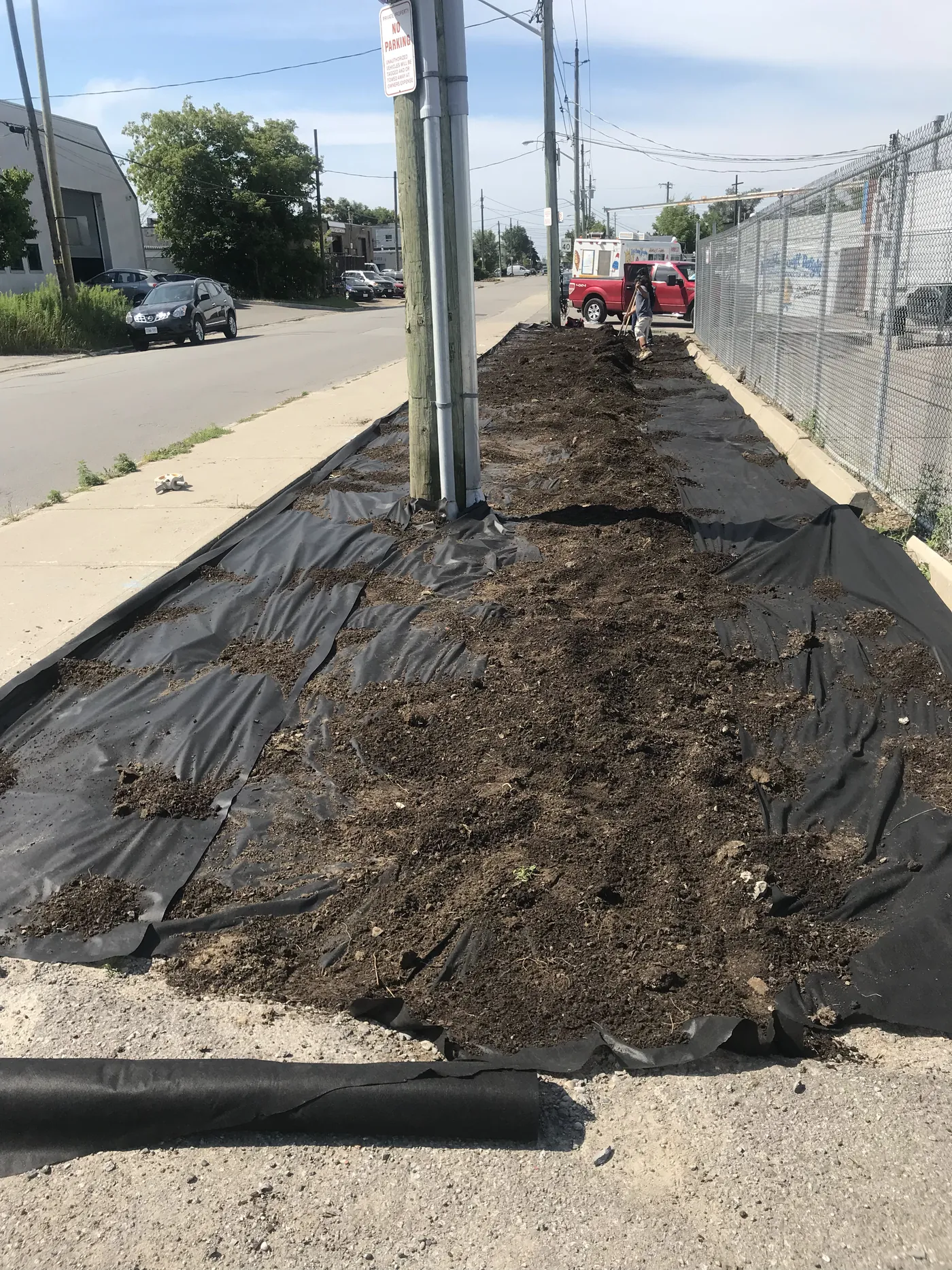 Landscape fabric pinned down and topsoil spread along the new fence line on the boulevard, Scarborough