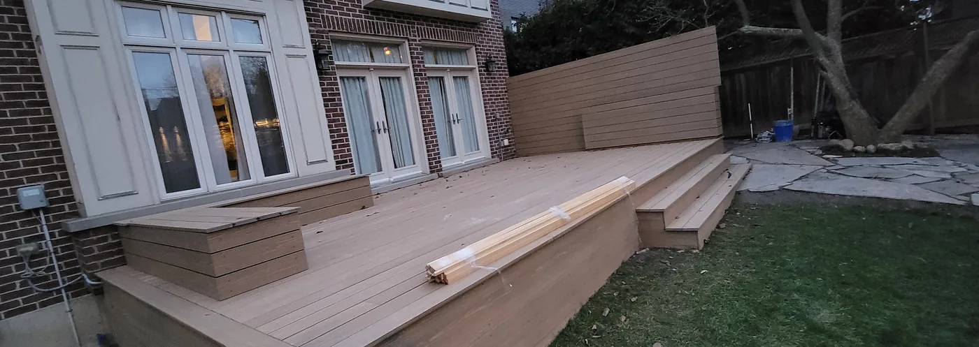 Composite deck across the back of a Toronto home with the rear yard beside it