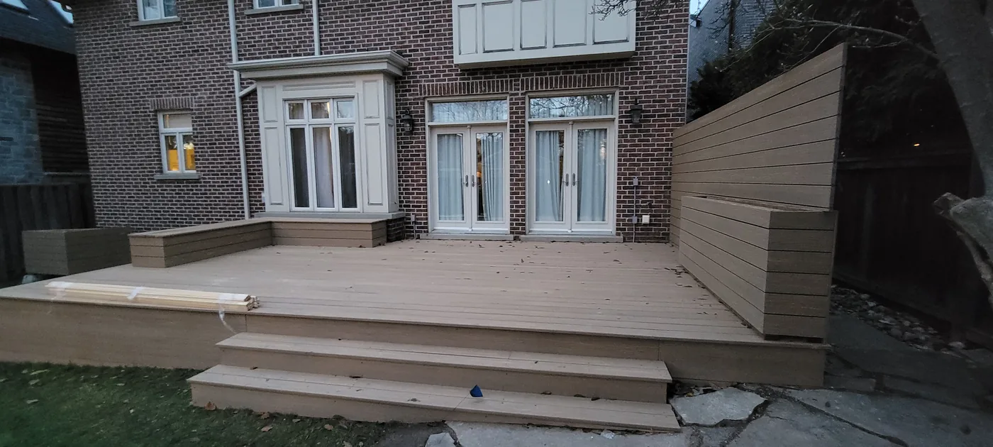 Wide composite steps from the deck down to a flagstone walkway in Toronto