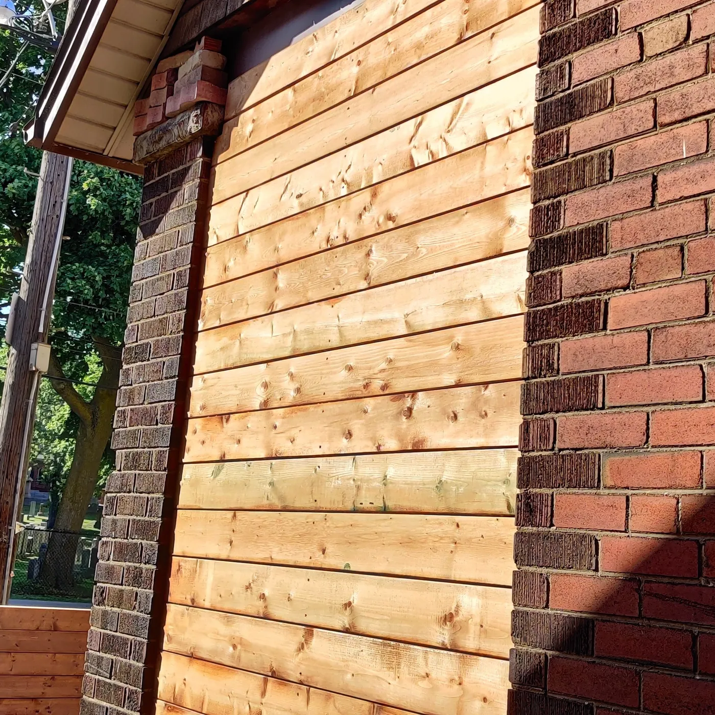 Close view of the cedar screen boards butting into the brick, Toronto
