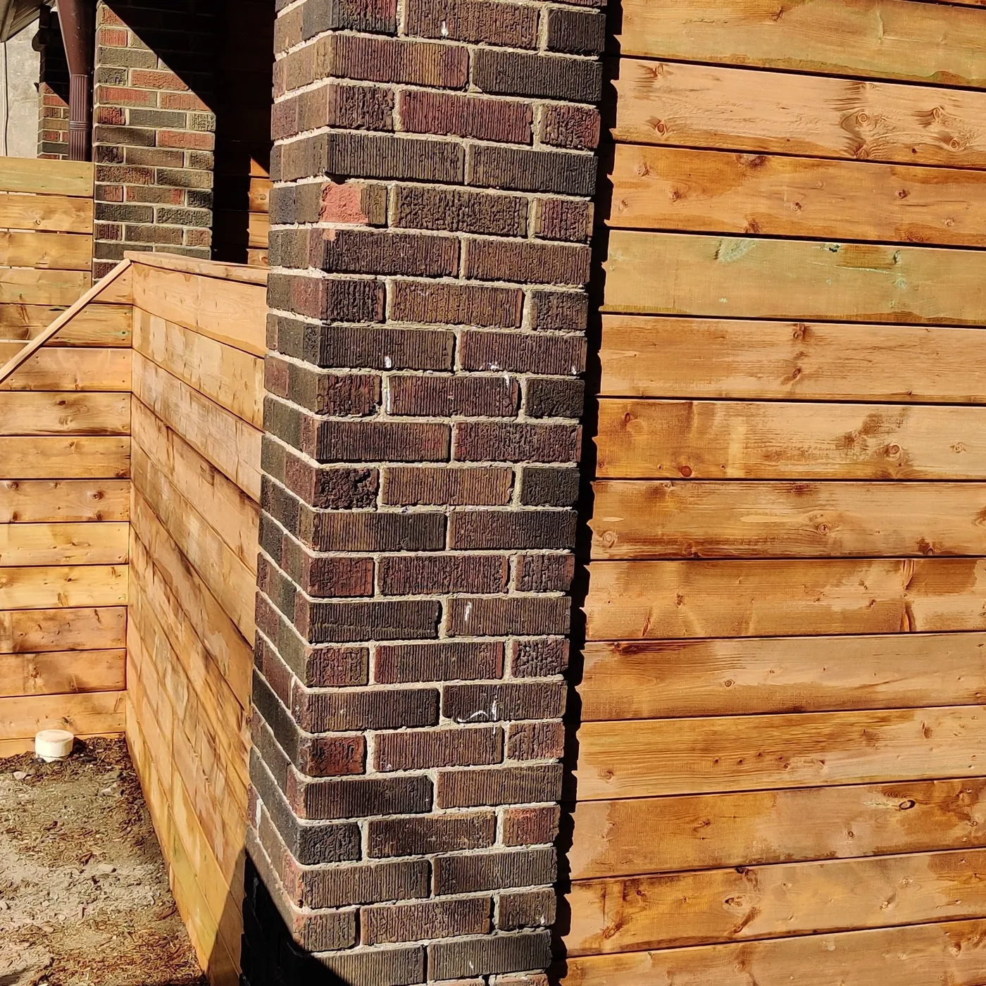 Horizontal cedar screen built around the original brick porch pier, Toronto