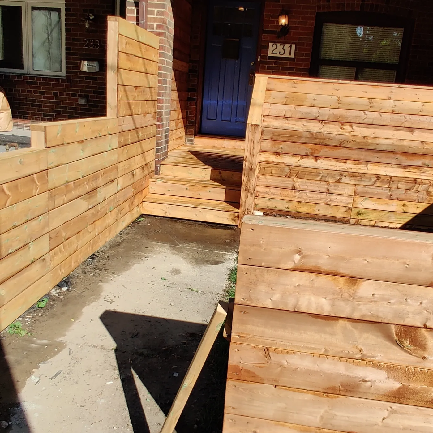 The privacy screen seen from the driveway with the porch entry beyond, Toronto