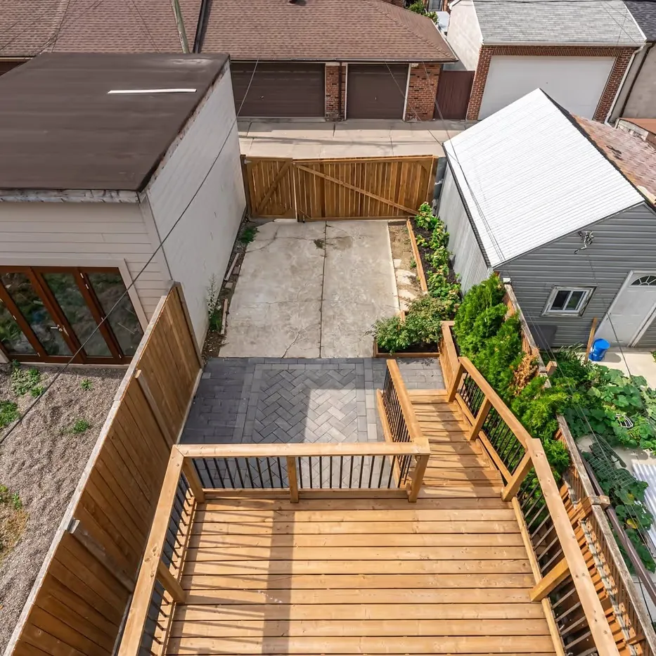 The deck, stairs and cedar fence looking down the rear yard to the garage, Toronto